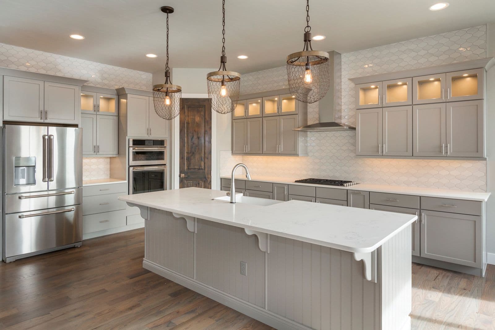 Bright, clean kitchen with white counters and warm pendant lighting